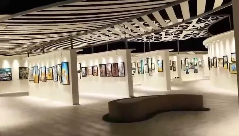 Completed FANN installation for the ADEK National Expression exhibition in Abu Dhabi, with curved gallery walls and spotlit student artwork
